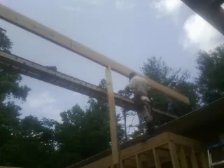 Carpenter setting a ridge beam over a new addition frame — Ice Dam Removal by Roofing Brothers in Interlaken