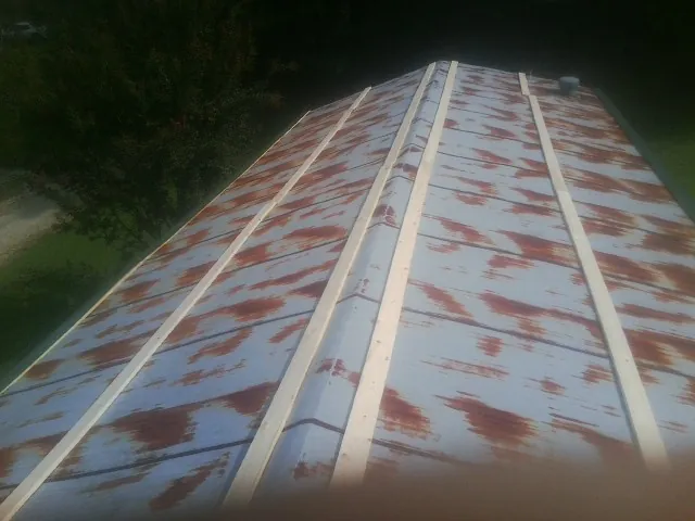 Rusted metal roof panels with new wood purlins before replacement — Storm Damage Roof Repair in Interlaken by Roofing Brothers