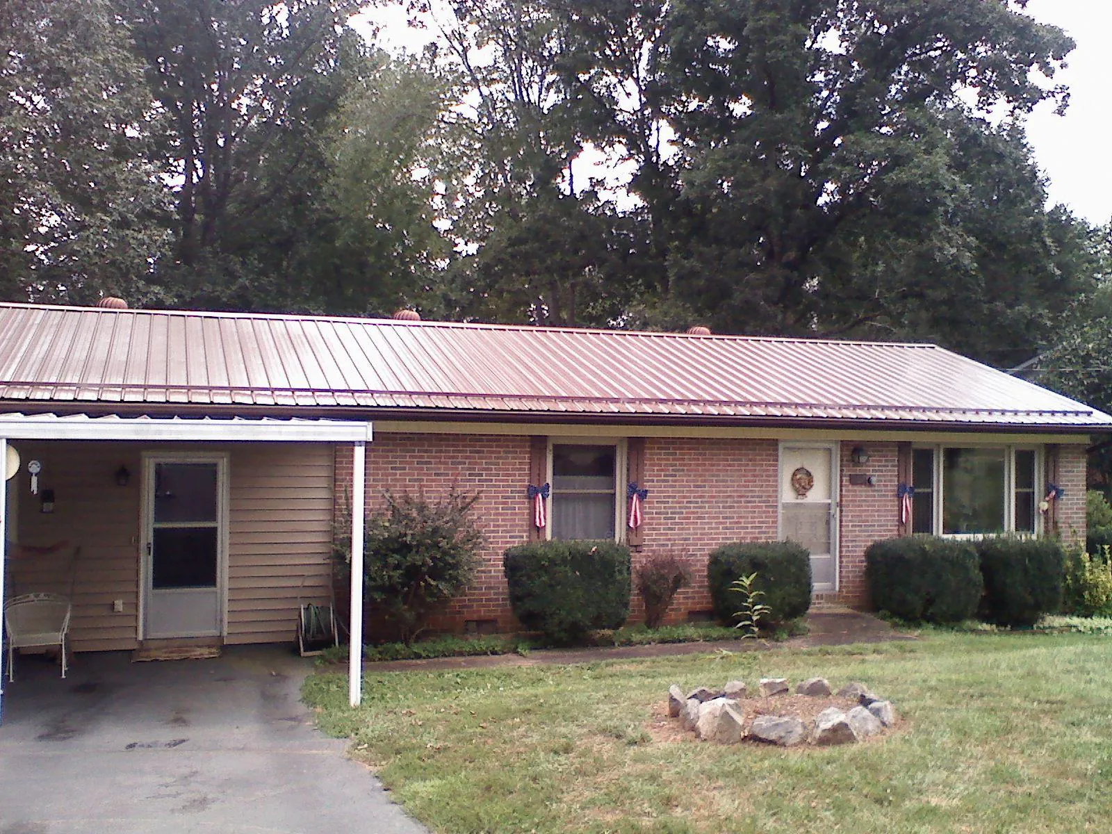 Bronze metal roof and carport on a brick ranch home — Roof Repair work by our crew in Interlaken